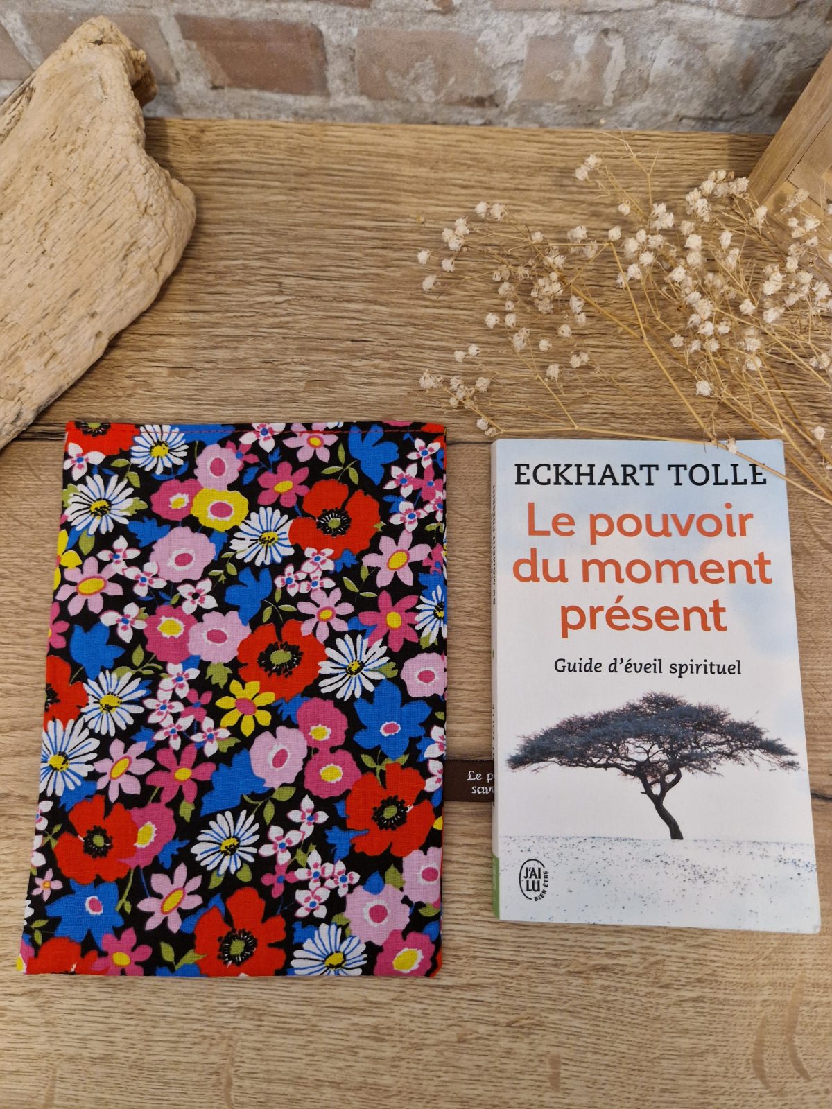 Cette pochette avec un tissu floral est un accessoire utile pour ranger votre livre du moment. Souple et tout en coton, elle convient aux formats livre de poche classique.