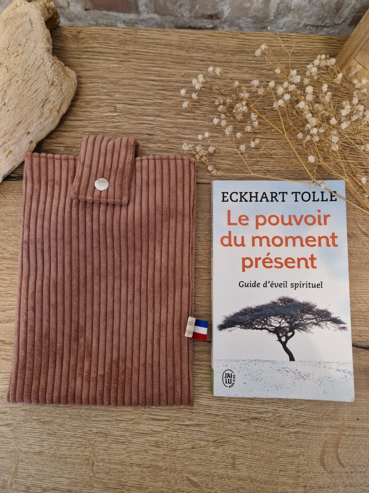 Cette pochette molletonnée avec des tissus uni est un accessoire utile pour ranger votre livre du moment. Tout en coton et molletonné pour une protection optimale, elle convient au format livre de poche classique. Ferme avec un bouton de pression. Ainsi vous pourrez le glisser dans votre sac sans abimer les angles.