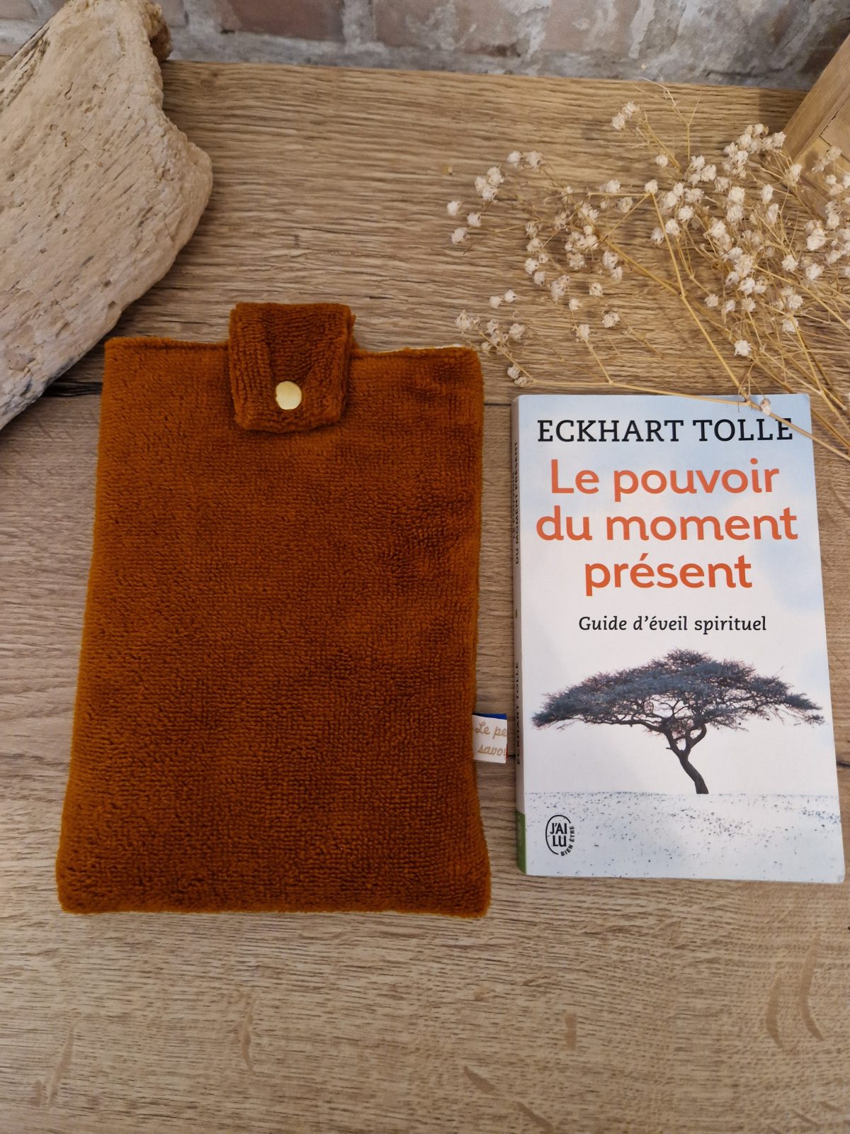 Cette pochette molletonnée avec des tissus uni est un accessoire utile pour ranger votre livre du moment. Tout en coton et molletonné pour une protection optimale, elle convient au format livre de poche classique. Ferme avec un bouton de pression. Ainsi vous pourrez le glisser dans votre sac sans abimer les angles.