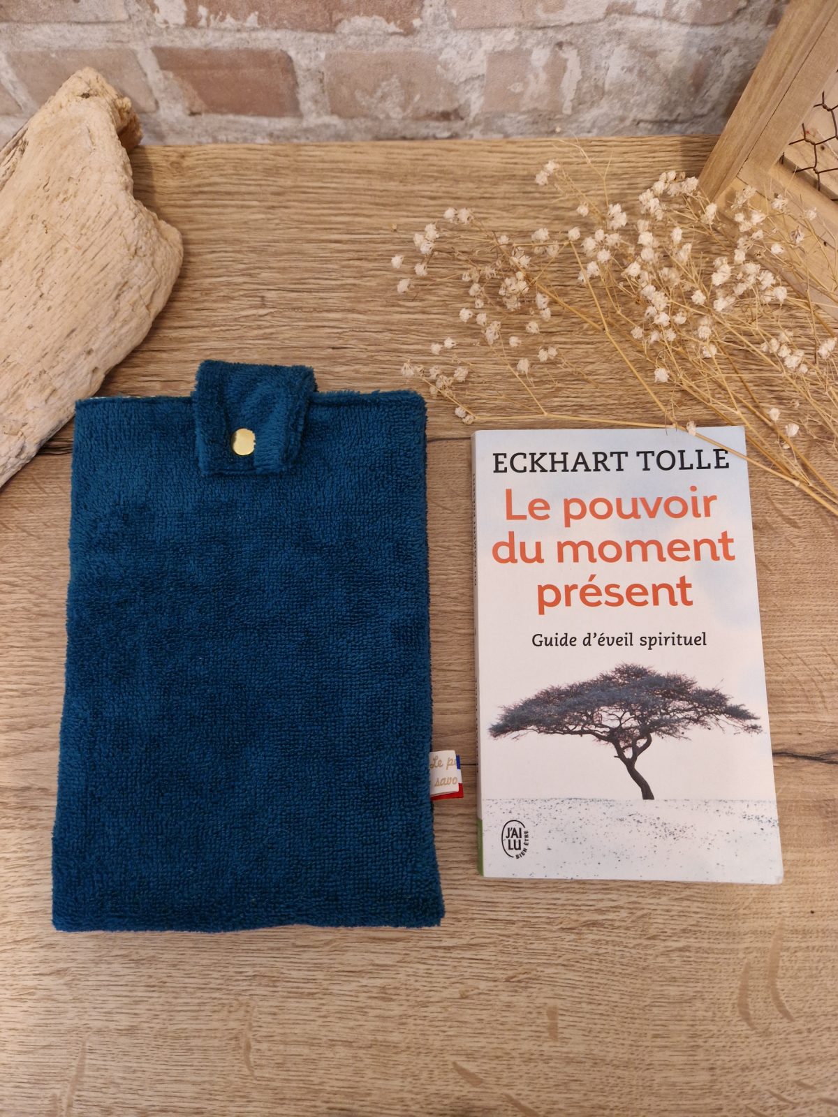 Cette pochette molletonnée avec des tissus uni est un accessoire utile pour ranger votre livre du moment. Tout en coton et molletonné pour une protection optimale, elle convient au format livre de poche classique. Ferme avec un bouton de pression. Ainsi vous pourrez le glisser dans votre sac sans abimer les angles.